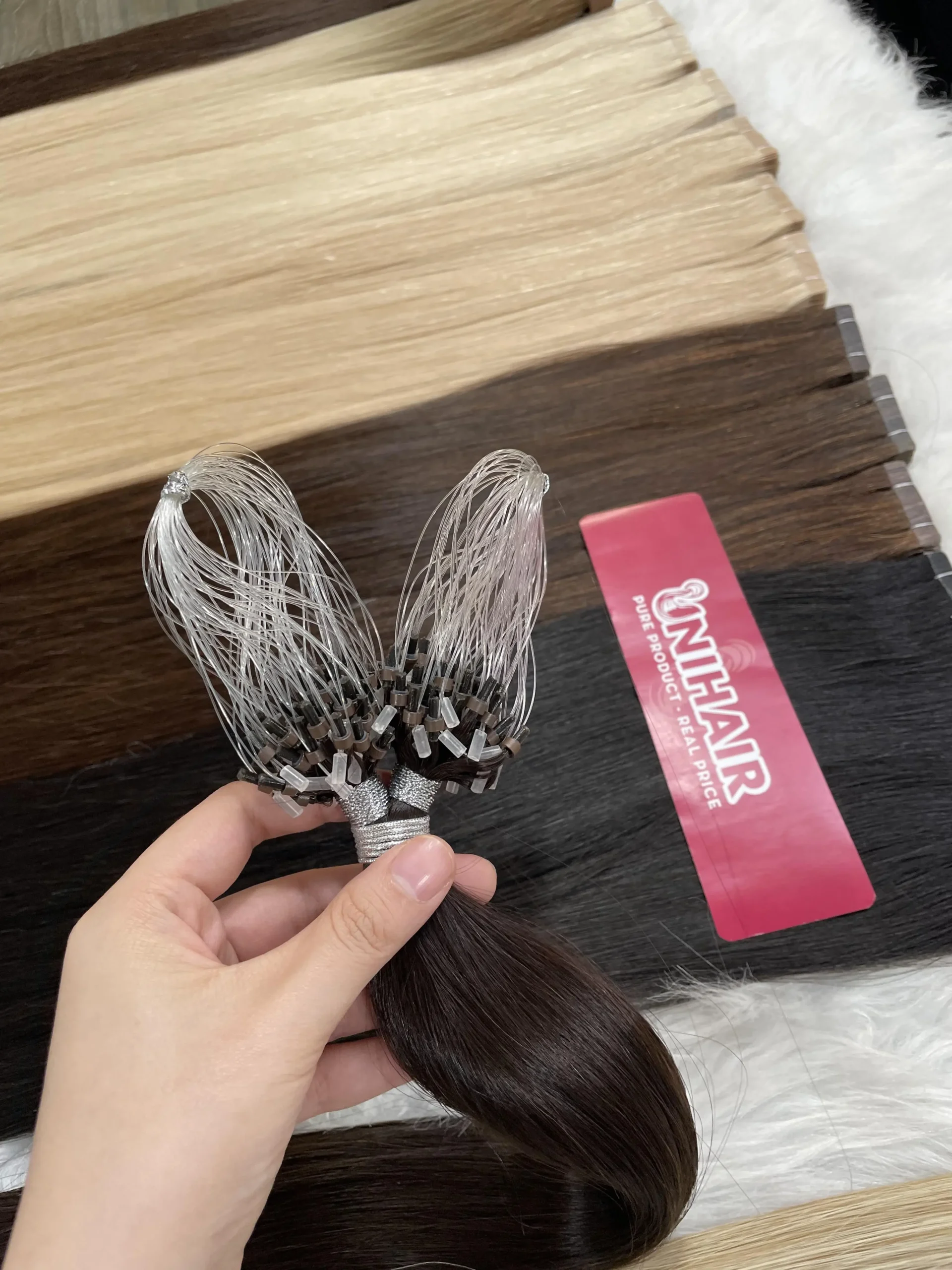 Micro Ring hair extension strands showing bead attachment detail for professional move-up service Micro Ring hair extension strands showing bead attachment detail for professional move-up service